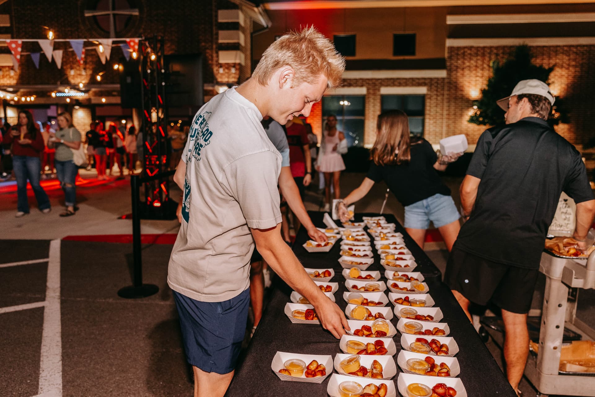 Guests picking up pretzel trays at a night event
