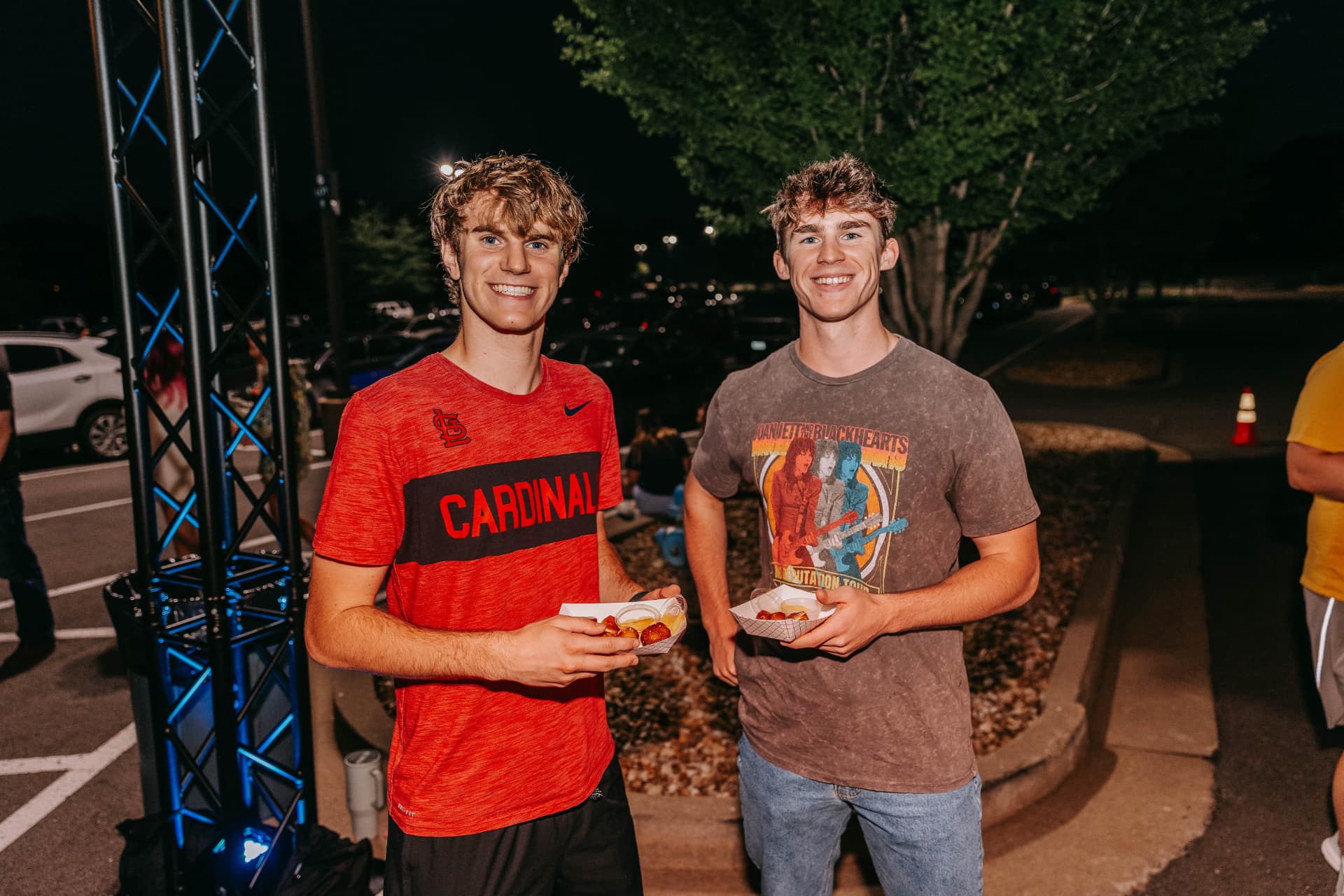 Guests smiling with pretzel trays at a summer welcome event