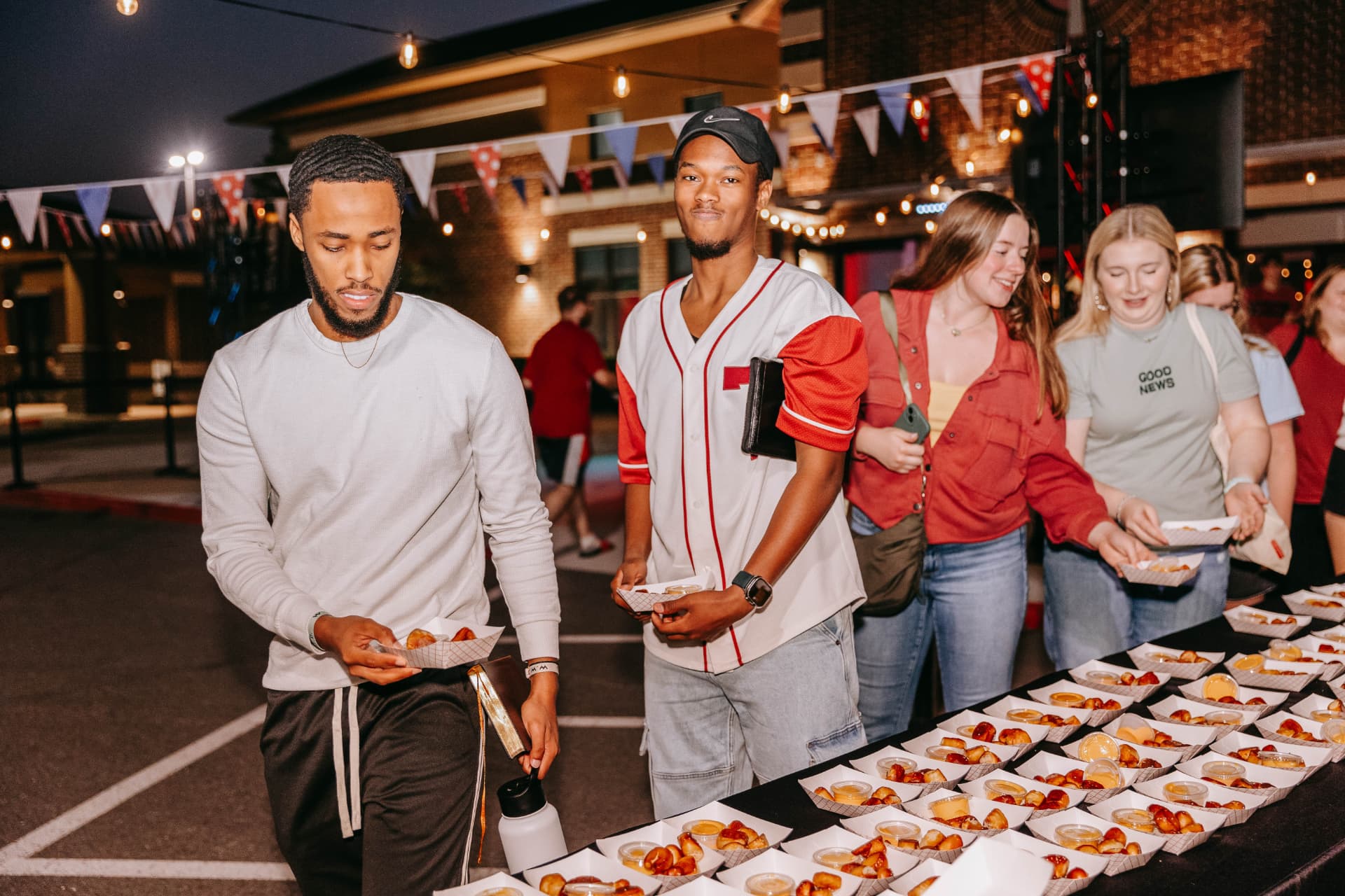 A crowd lining up for pretzel bites at a night market